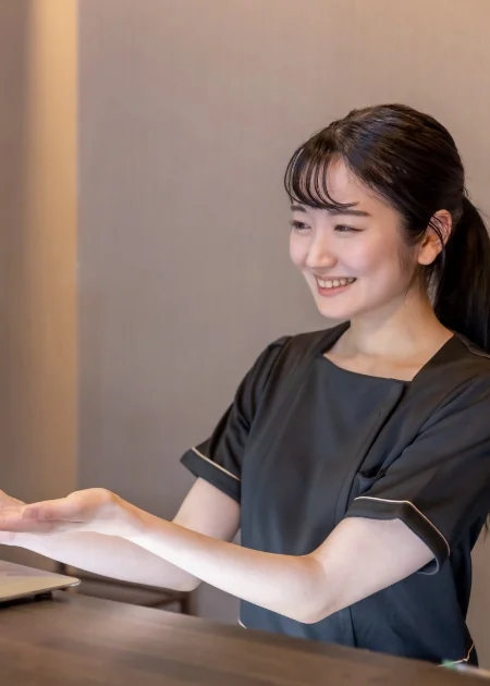 笑顔で受付する女性スタッフ